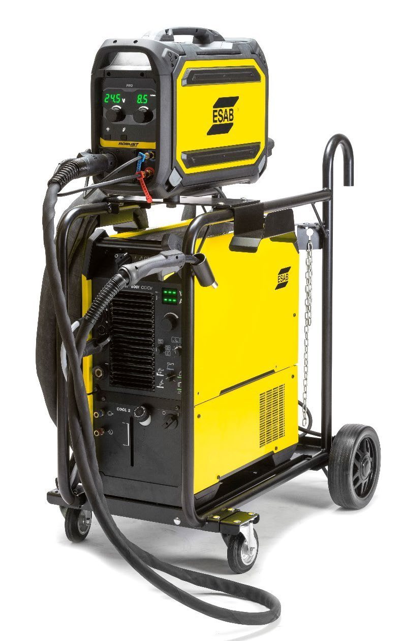 ESAB Warrior 500i CC/CV power source on a four-wheel trolley with a RobustFeed Pro wire feeder on top reading 24.5 V and 8.5 m per minute, with MIG torch and interconnection cables fitted